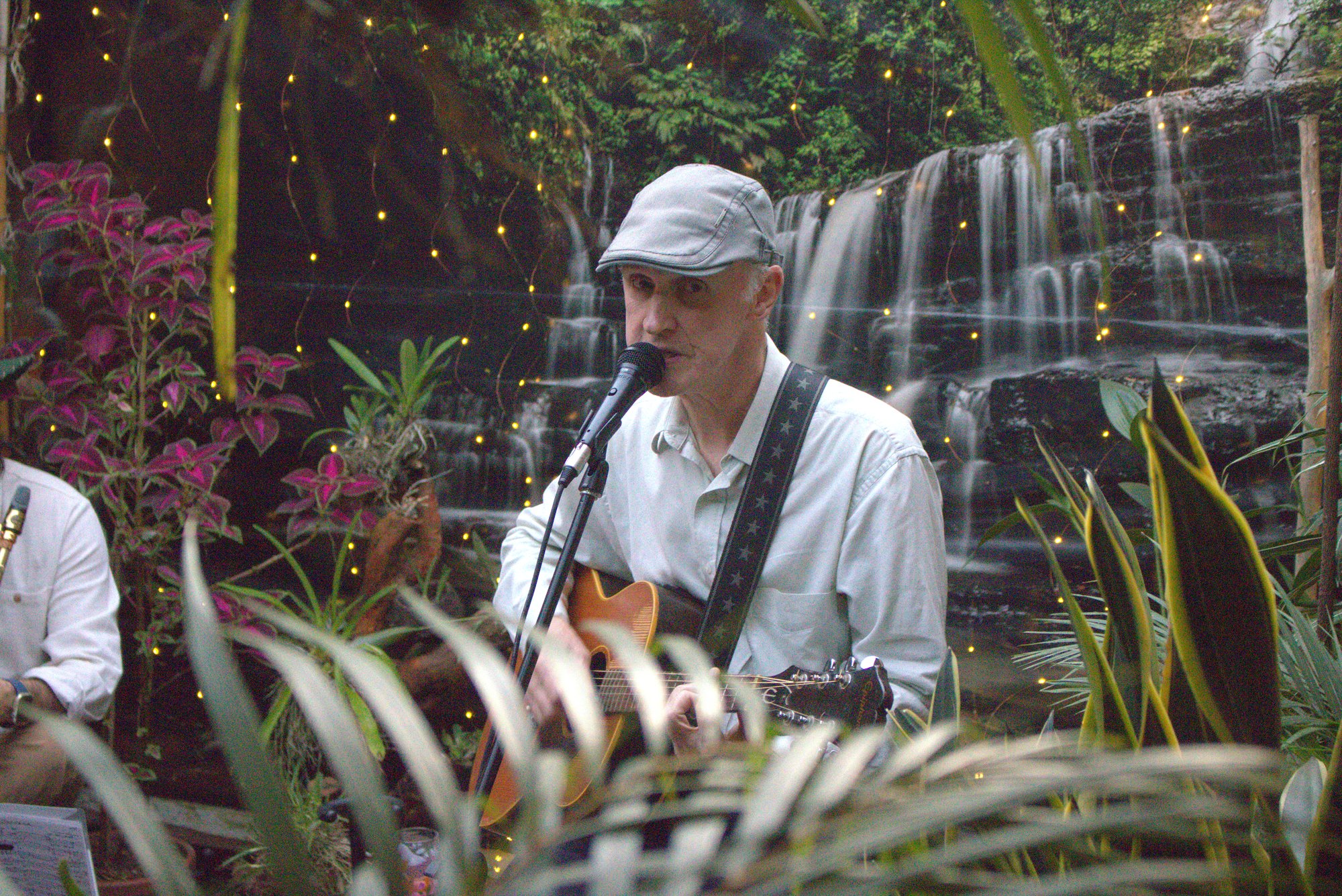 Músico de Jazz al Patio cantando y tocando guitarra en una Tenue Session